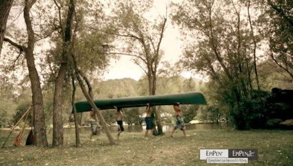 people carrying a canoe through the woods