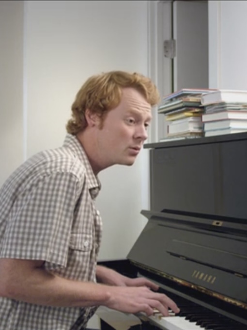 man with red hair playing the piano