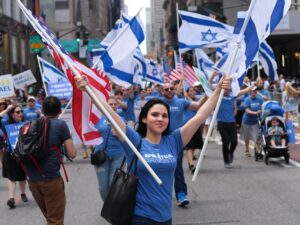 woman holding israel and usa flags in the street