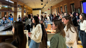 group of women in a brick office, listening to a presentation