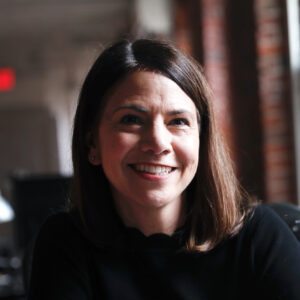 woman with brown hair sitting in a brick office