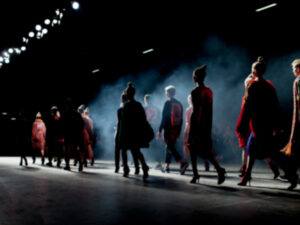 group of models walking on a dark runway