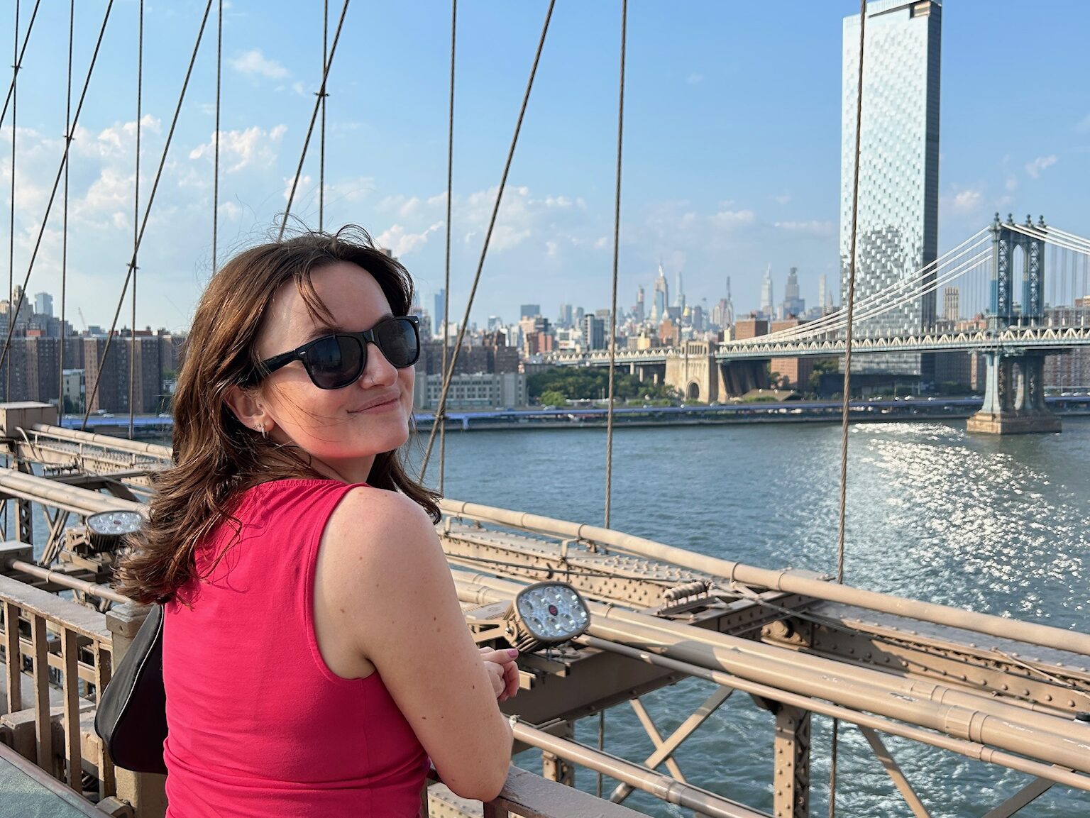 woman standing on bridge overlooking new york city