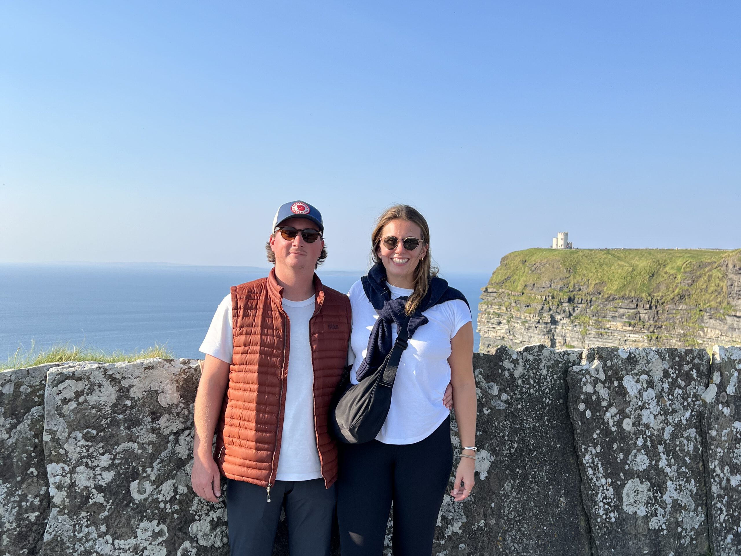 couple standing by a stone wall