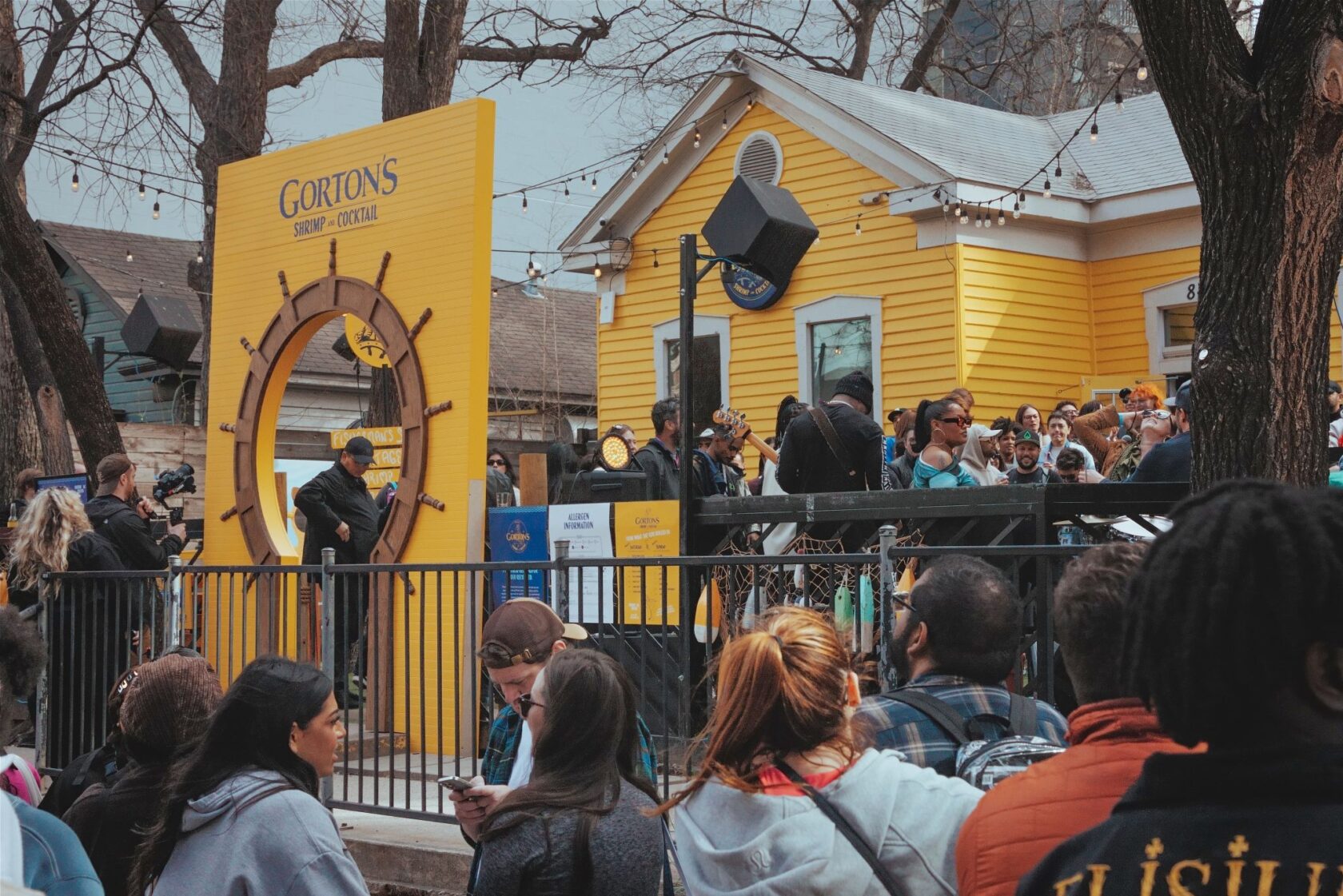 Image of people in and around a yellow house